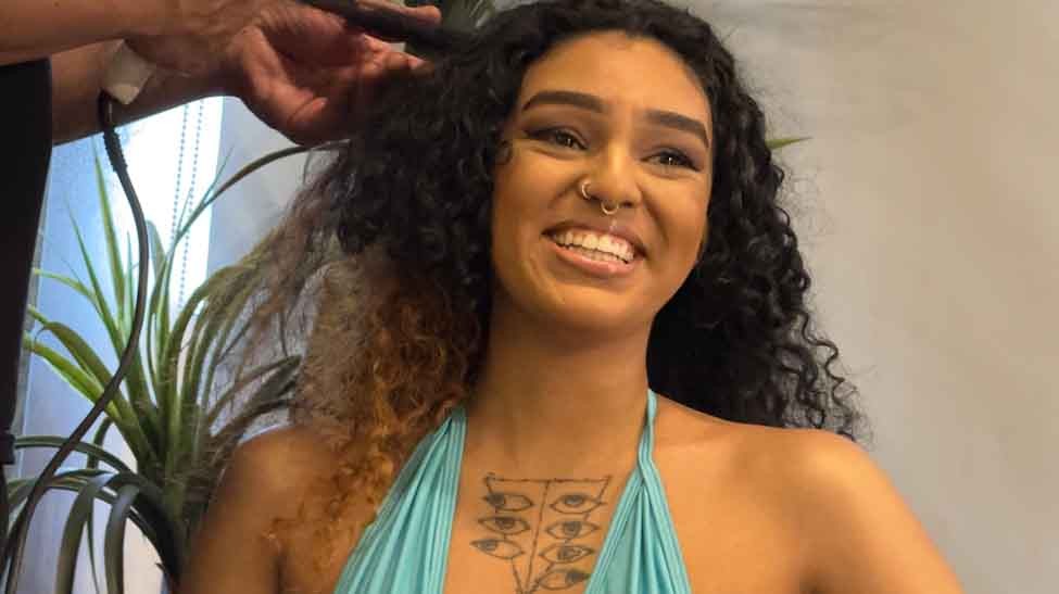 Com produção de beleza, Aline Morini se prepara para sua cena.